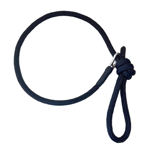 Black dog leash with a knot on a white surface